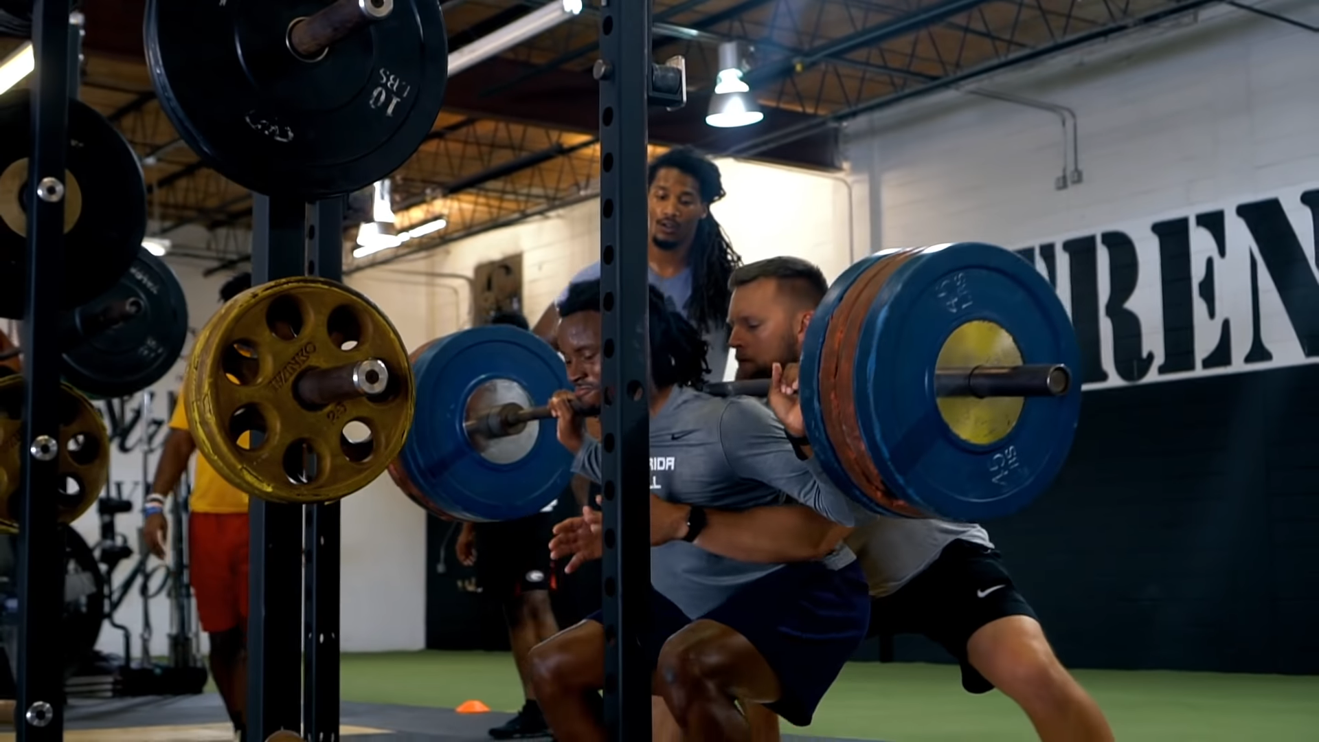 Football player performs back squat