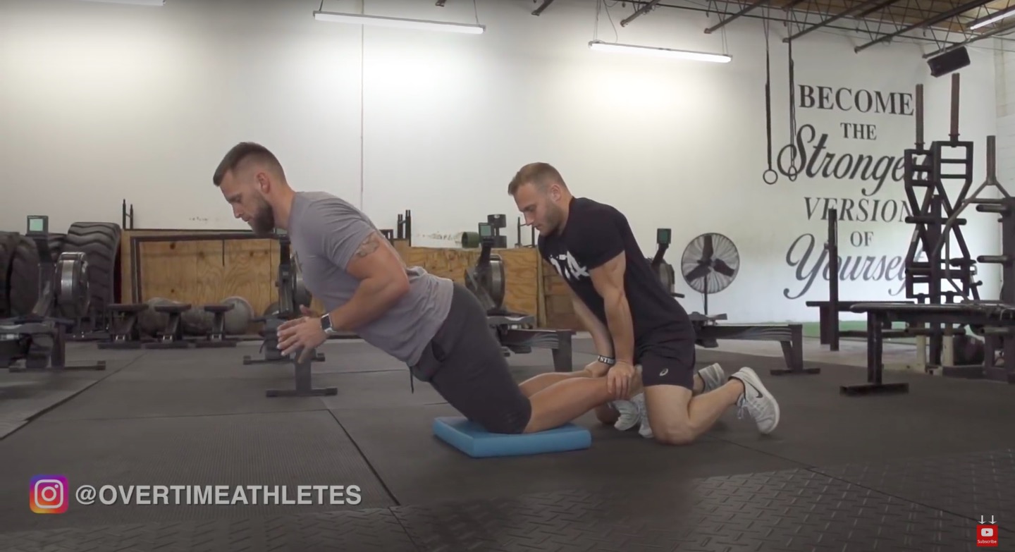 Athlete performs buddy hamstring curls